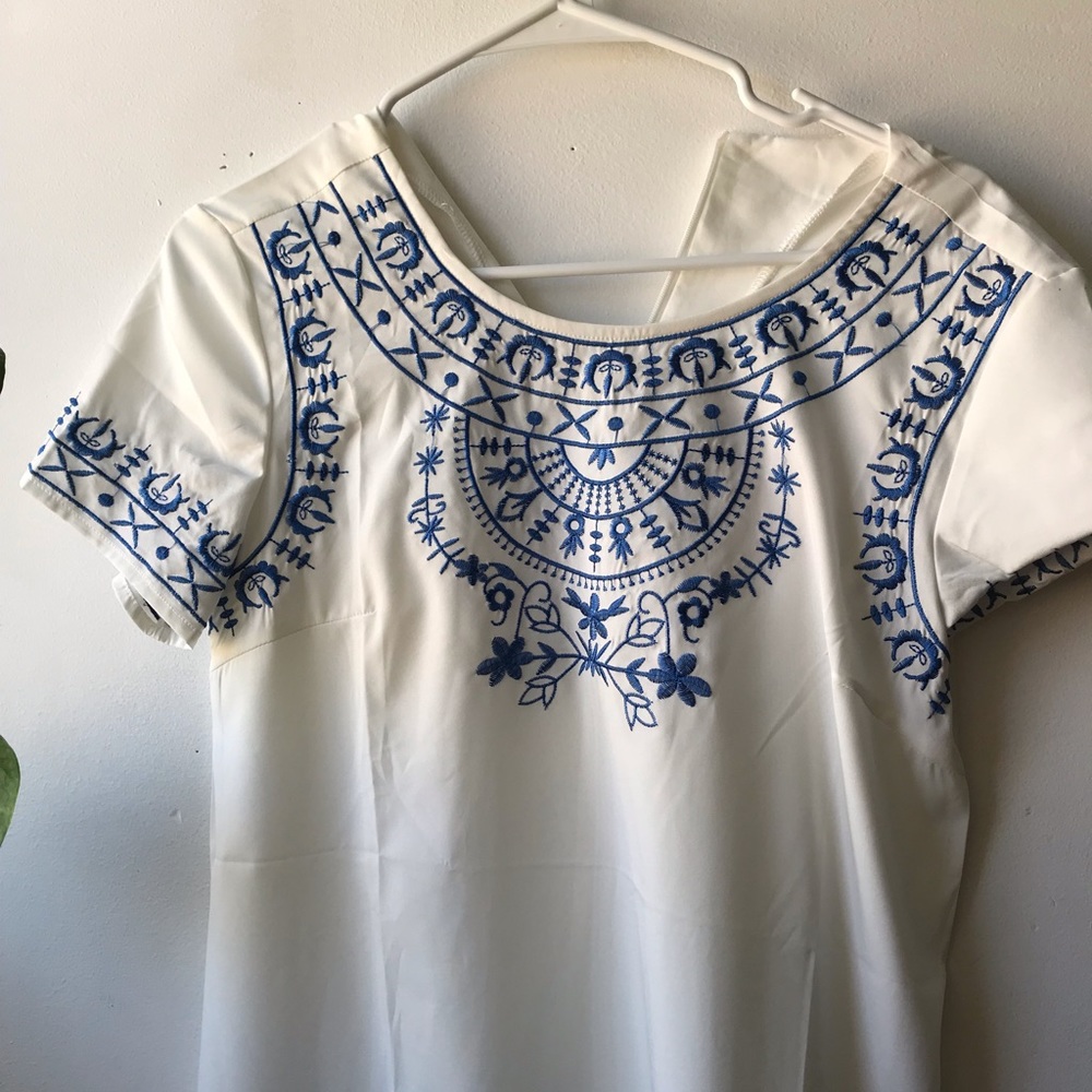 White dress with blue embroidery